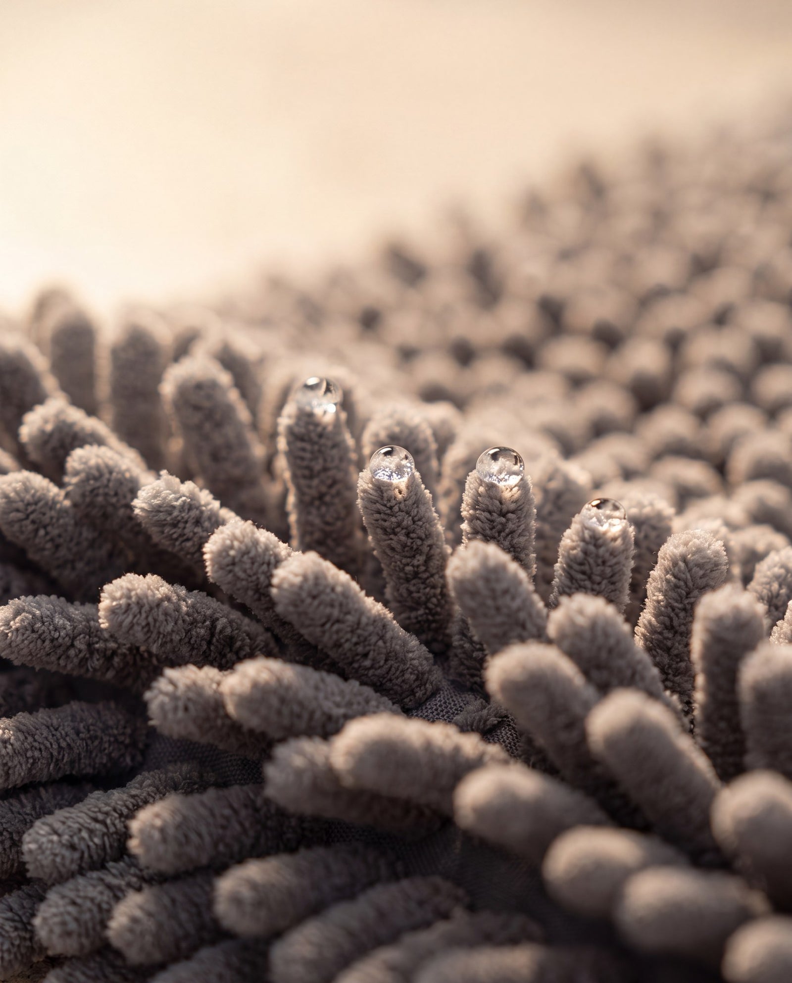 Macro detail of the Reset Mat chenille noodle fibres with water droplets showing absorbency
